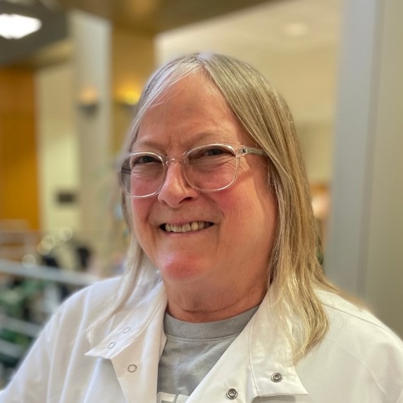 woman with gray hair wearing glasses and a lab coat