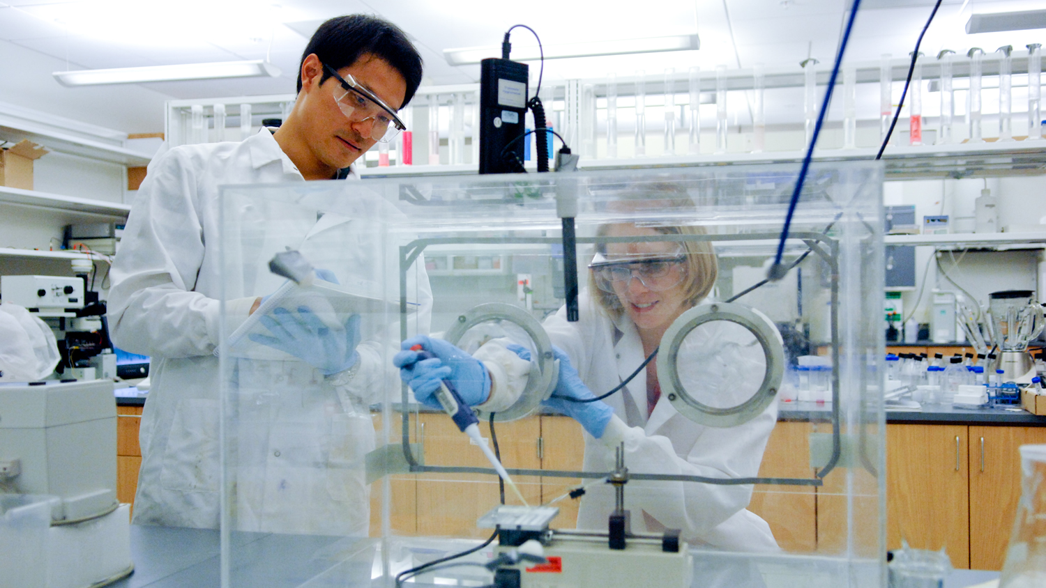 two students wearing PPE working in a lab