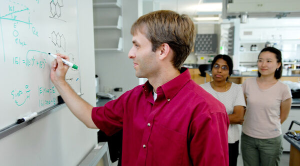 Prof. Dickey writing on the whiteboard in front of students