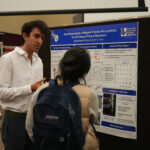 man speaking to another person about his research poster