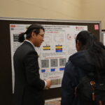 man speaking to another person about his research poster