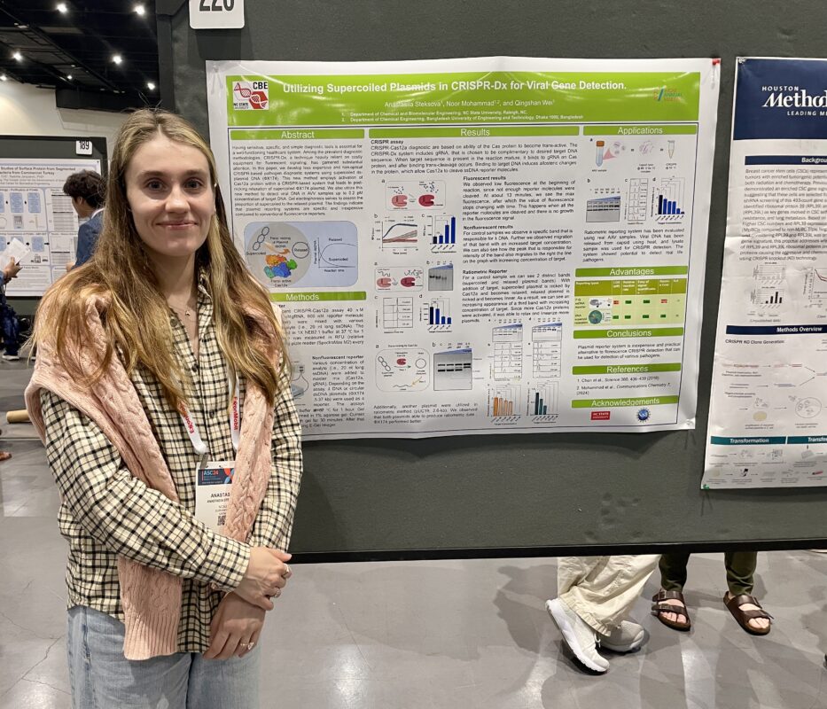 girl standing next to a research poster