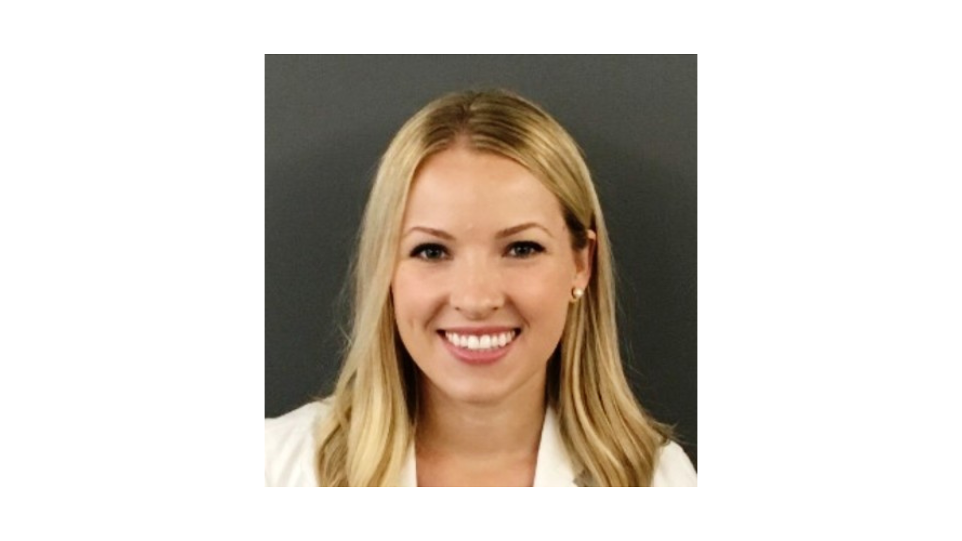 woman with blonde hair wearing a white blazer smiling