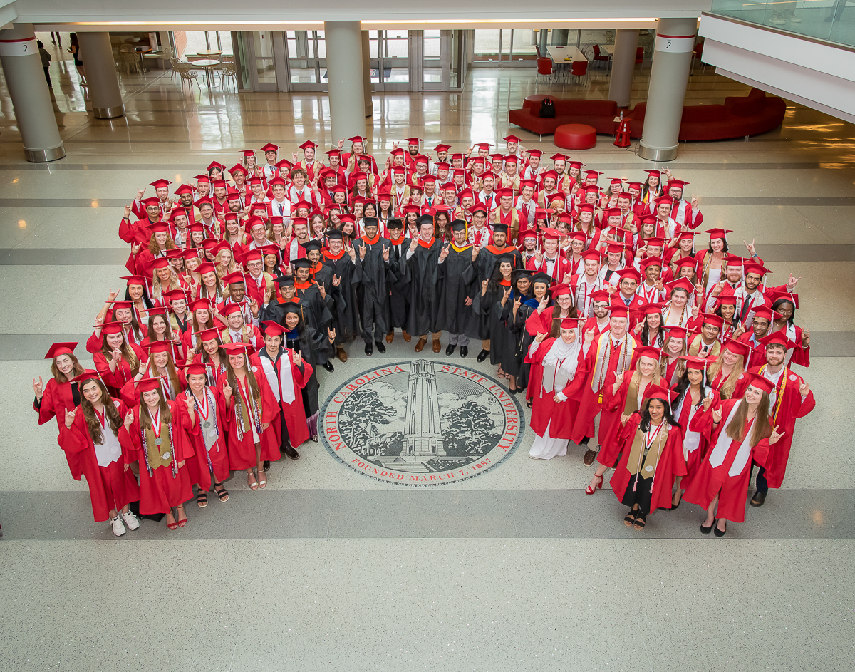 class of 2025 group photo around the NC State seal