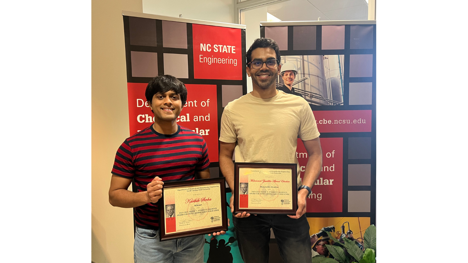 a picture of the two winners holding their plaques