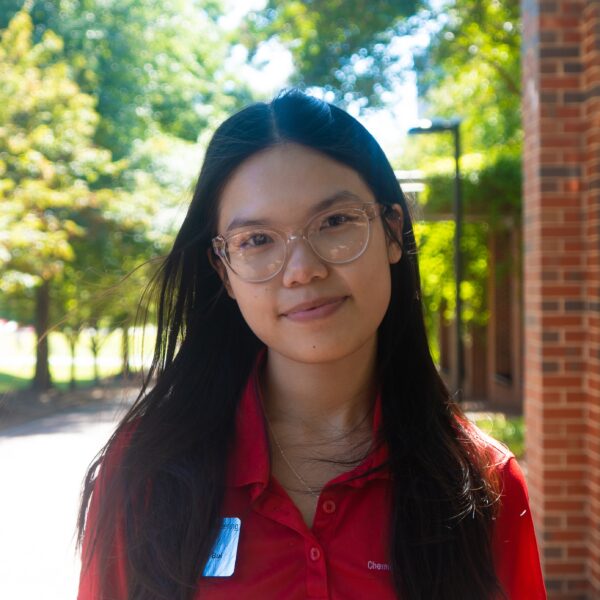 girl with long dark hair wearing glasses and a red polo