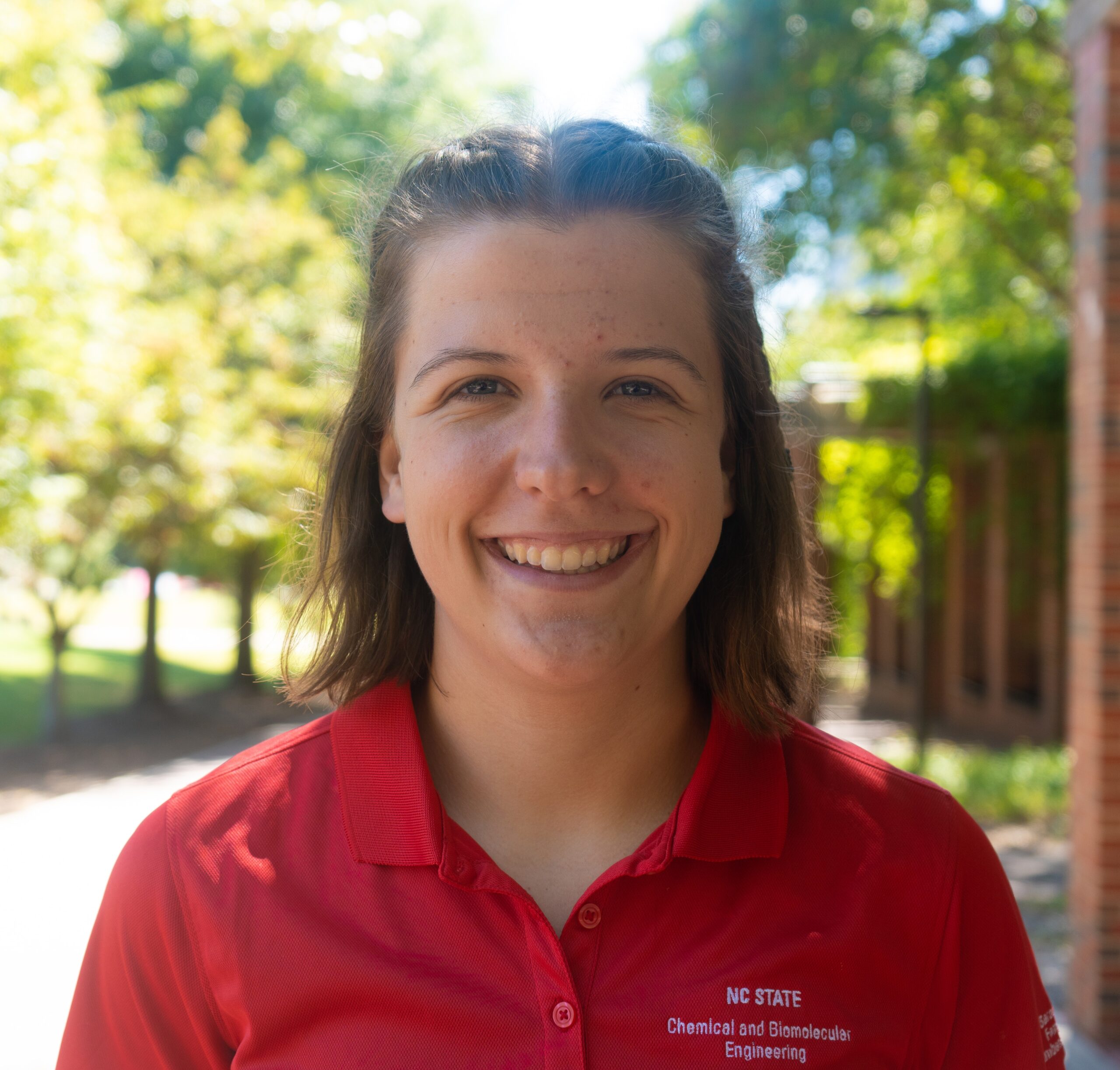 girl with short brown hair wearing a red polo