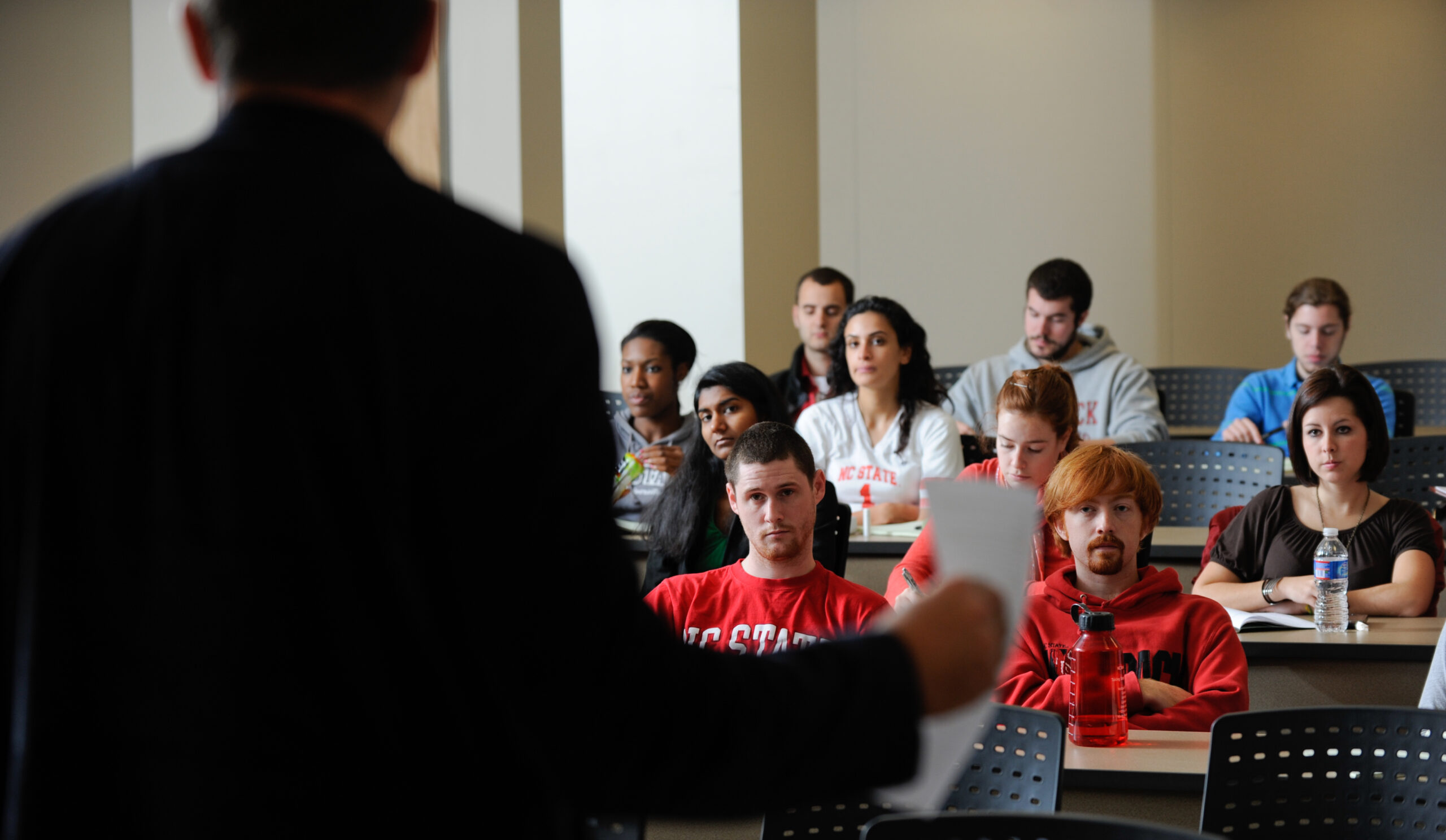 students listening to a teacher in a classroom