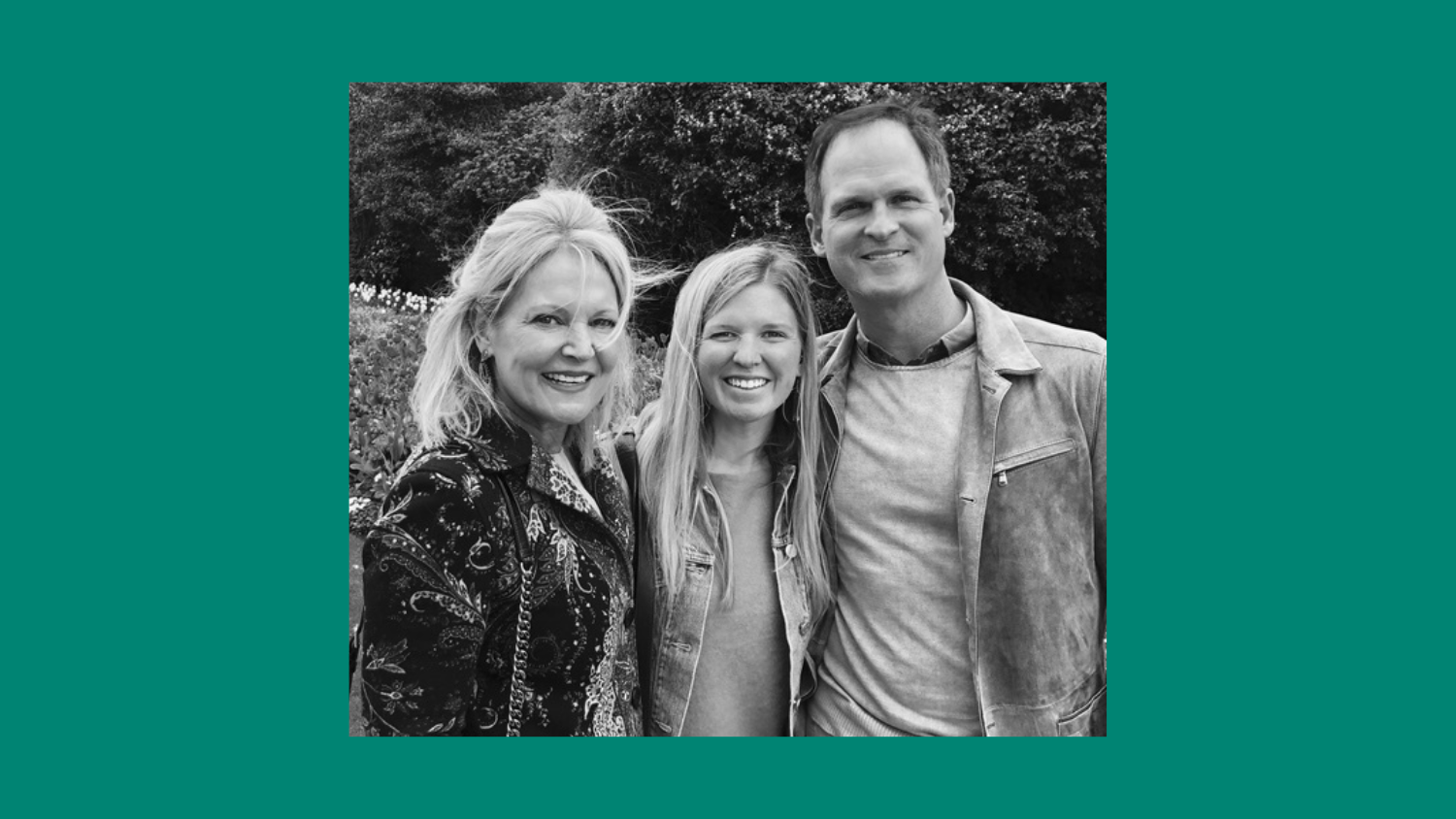 a group of three people smile and hug