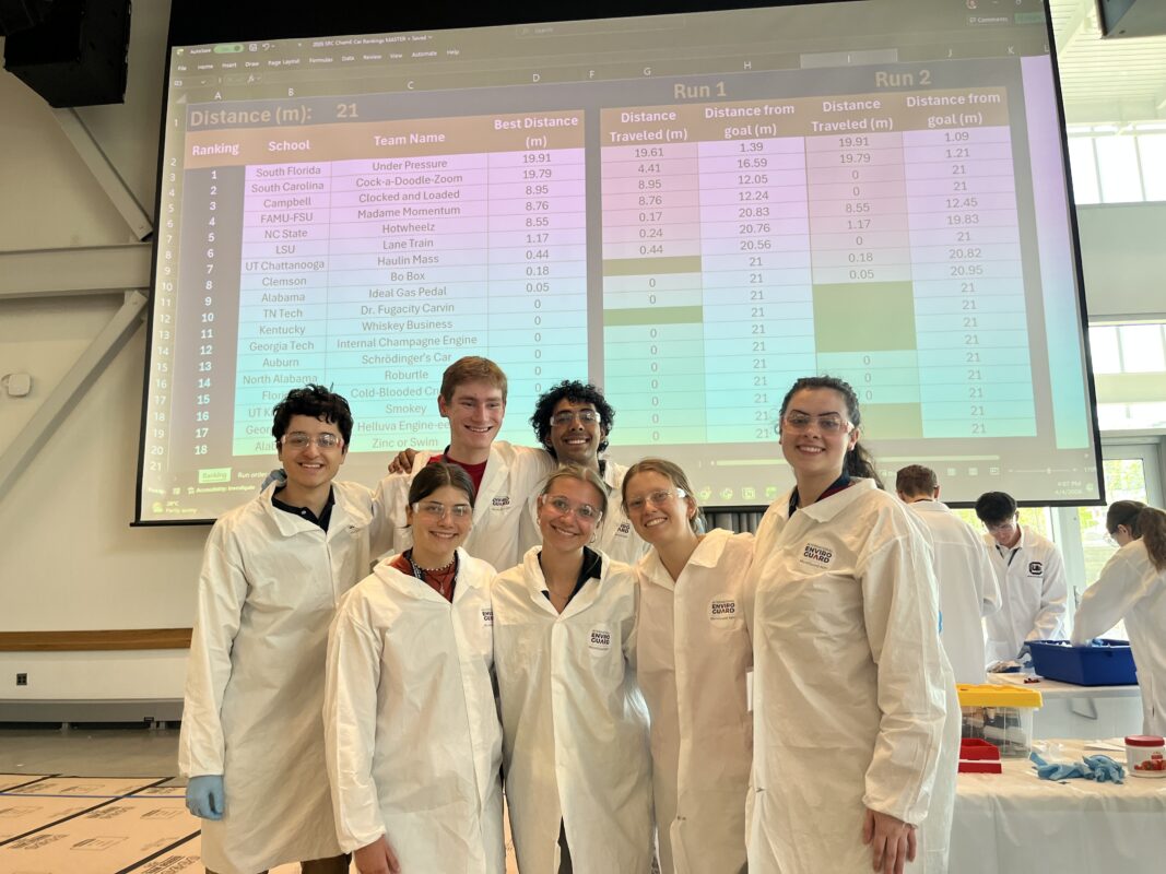 a group of students in PPE pose together and smile