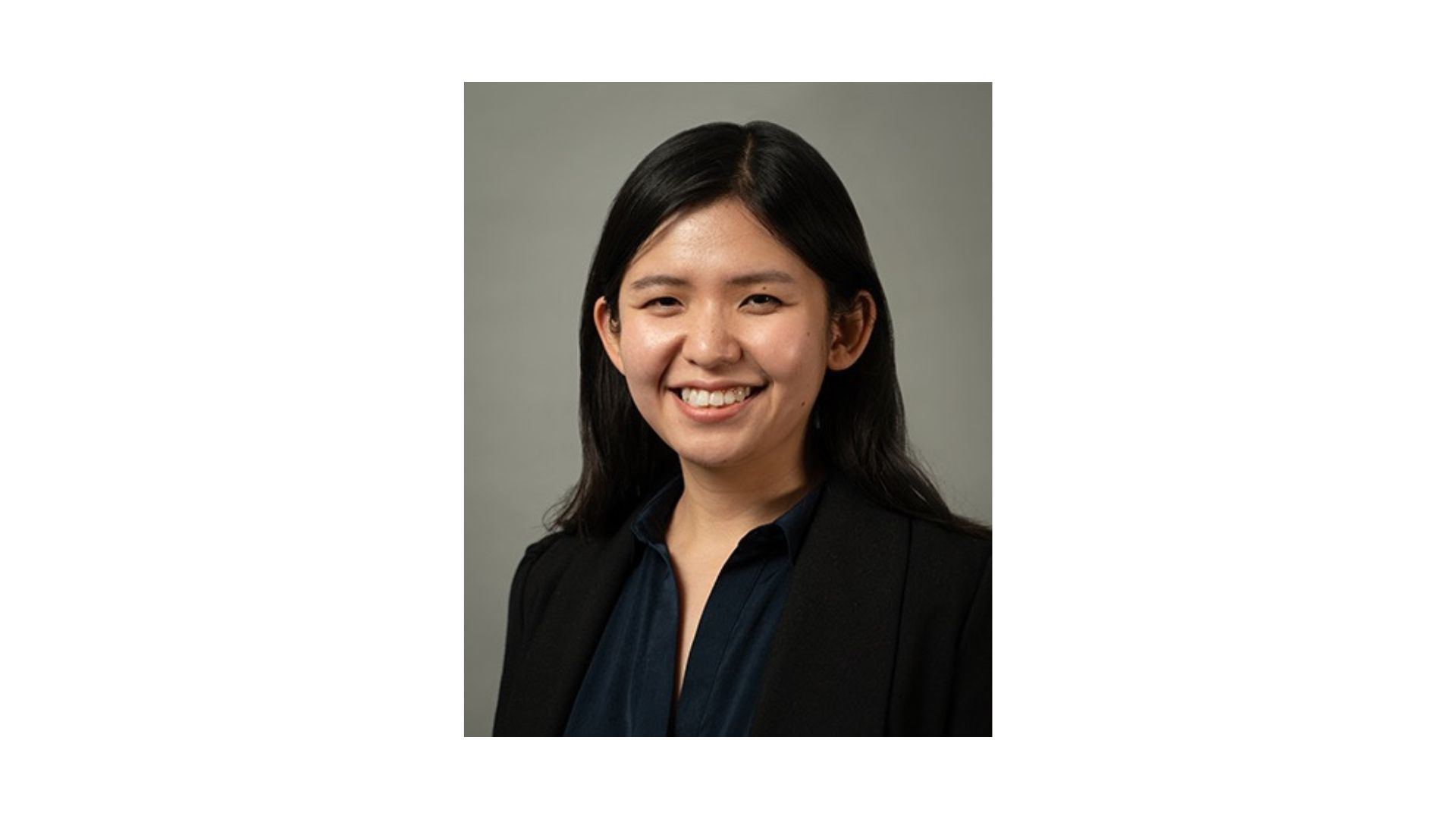 woman with long dark hair wearing a black shirt and smiling