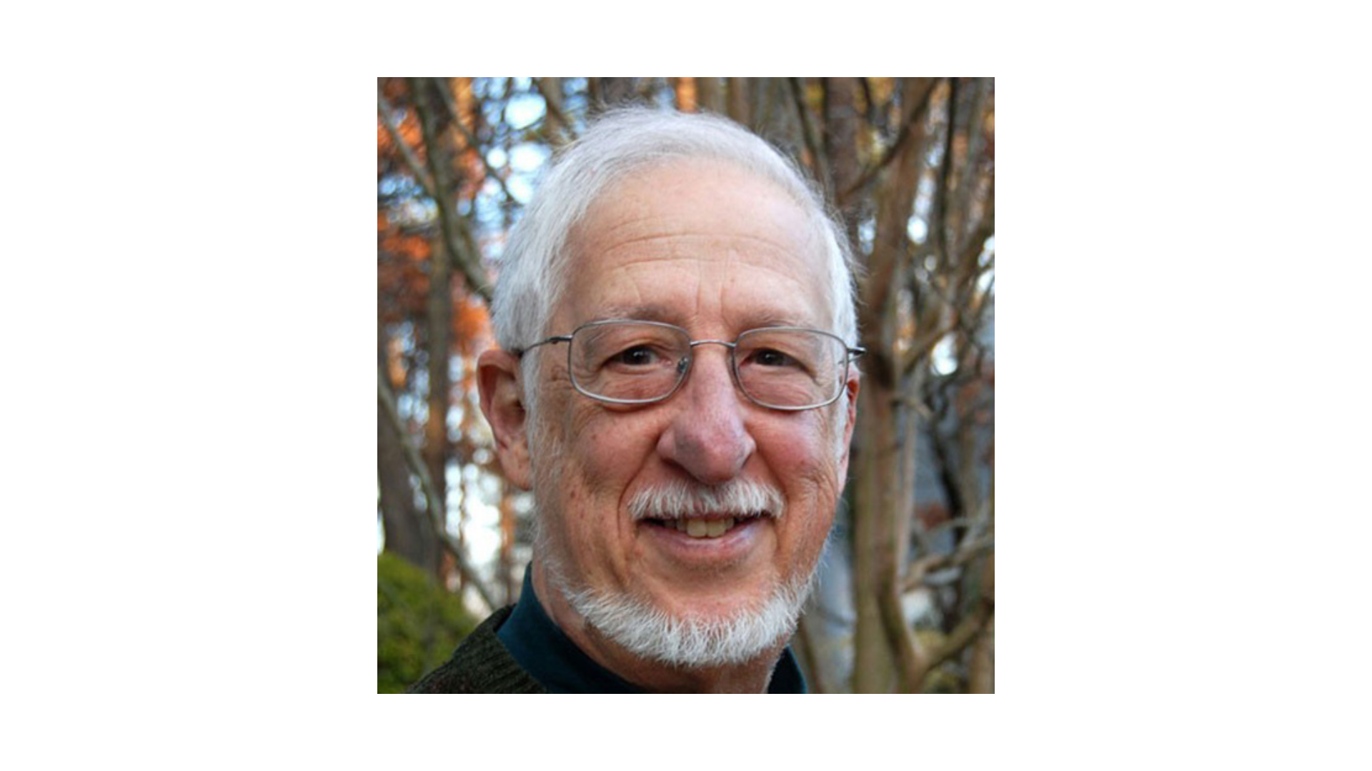 man with white hair and facial hair wearing glasses