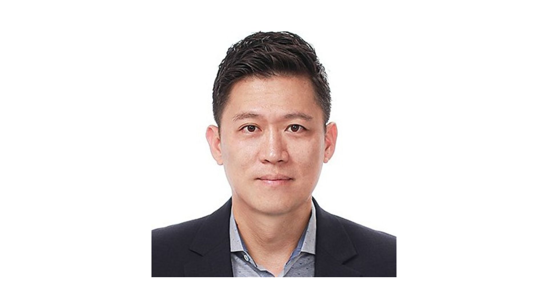 man with short dark hair wearing a suit in front of a white background